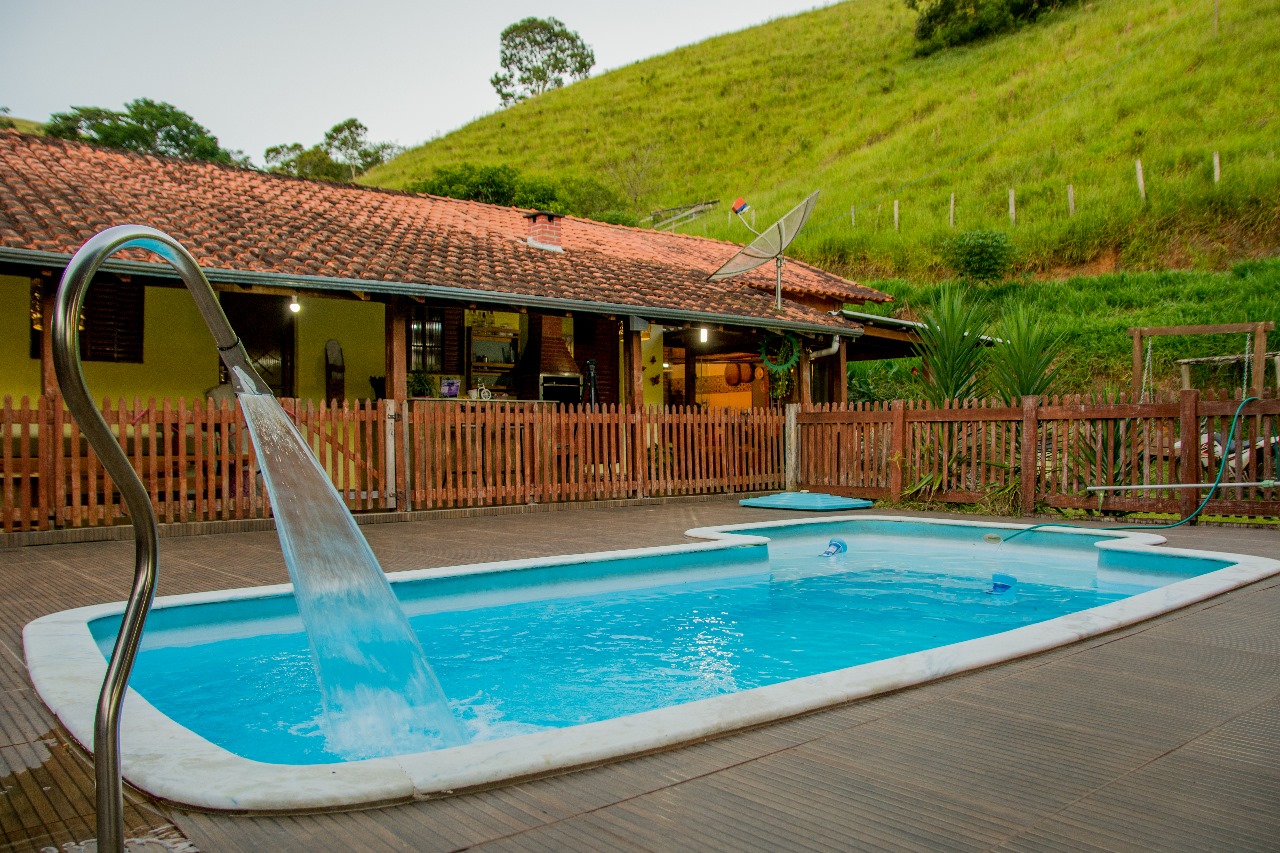 Piscina com cascata e vista para os morros