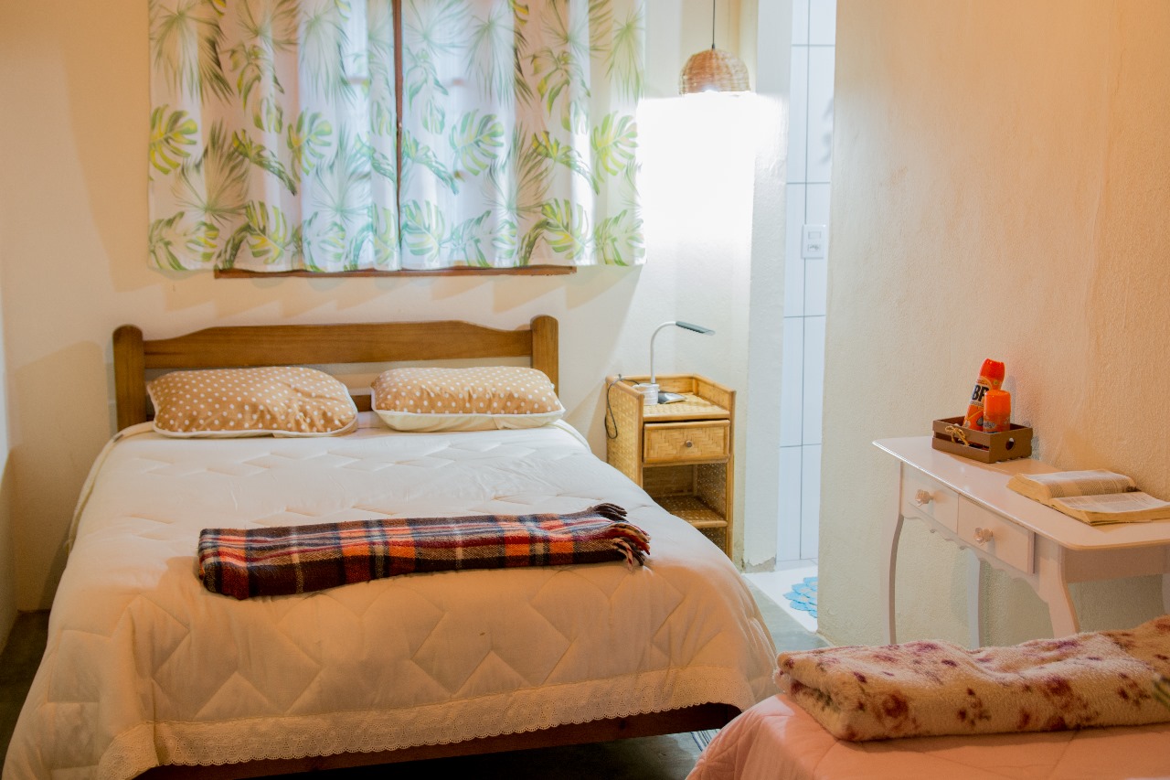 Quarto com cama de casal e decoração campestre